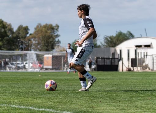 Dynamic action shot of a soccer player mid-game on a sunny day.